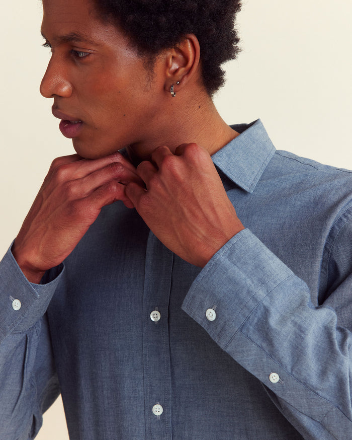 Model adjusts the collar of the shirt.