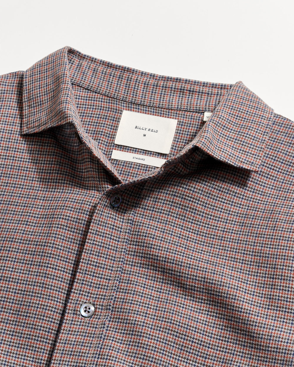 Checkered shirt with a visible brand label on a light gray background