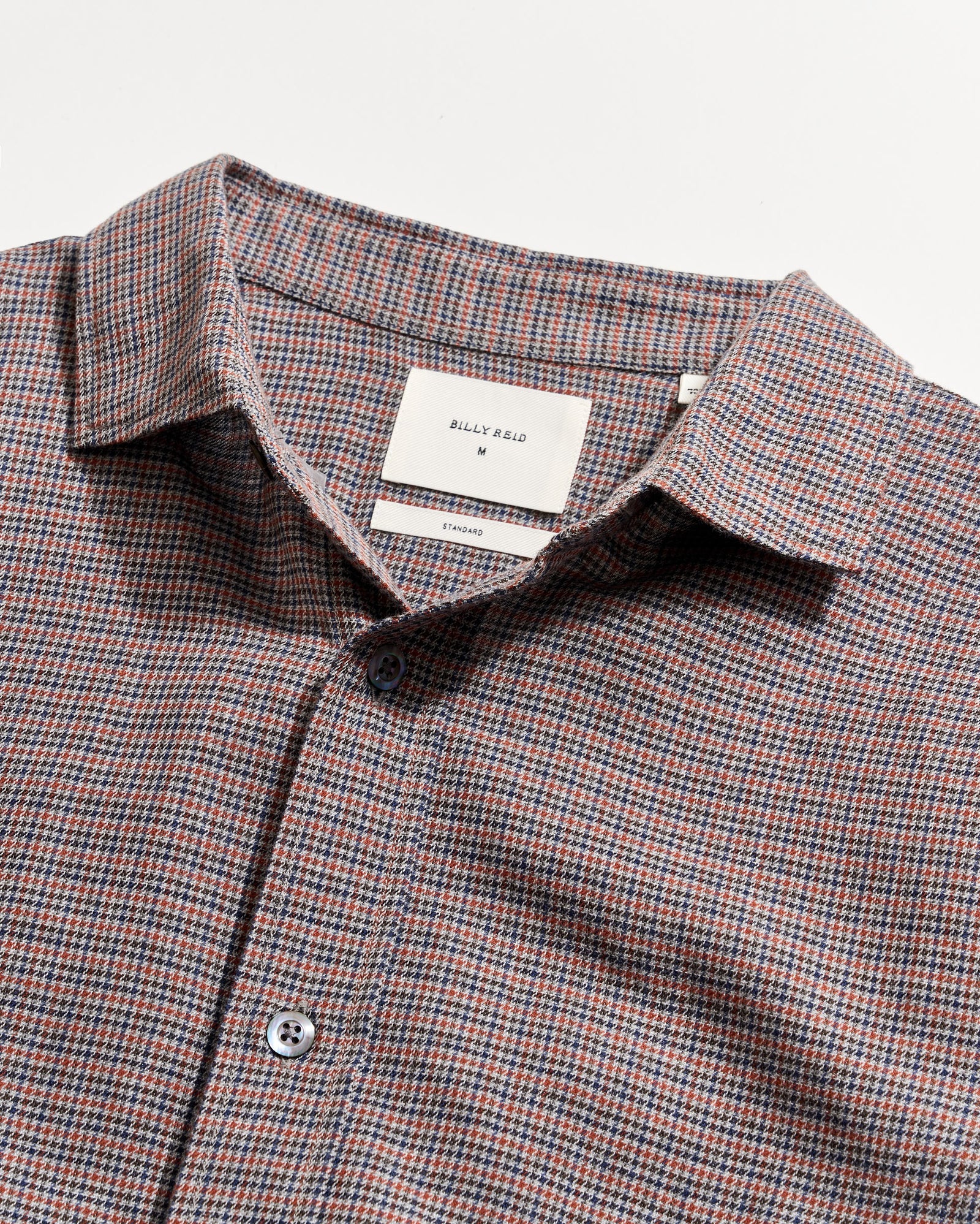 Checkered shirt with a visible brand label on a light gray background