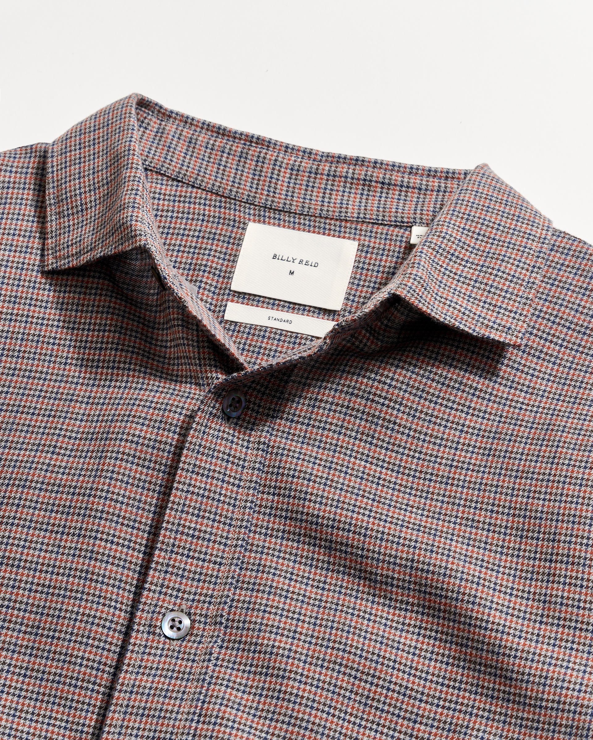 Checkered shirt with a visible brand label on a light gray background