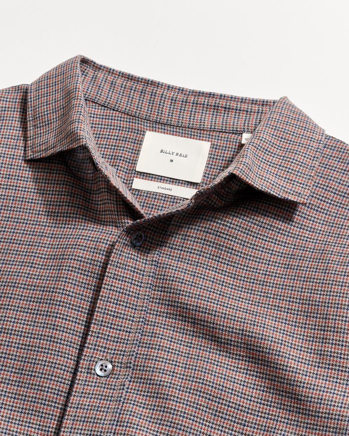 Checkered shirt with a visible brand label on a light gray background