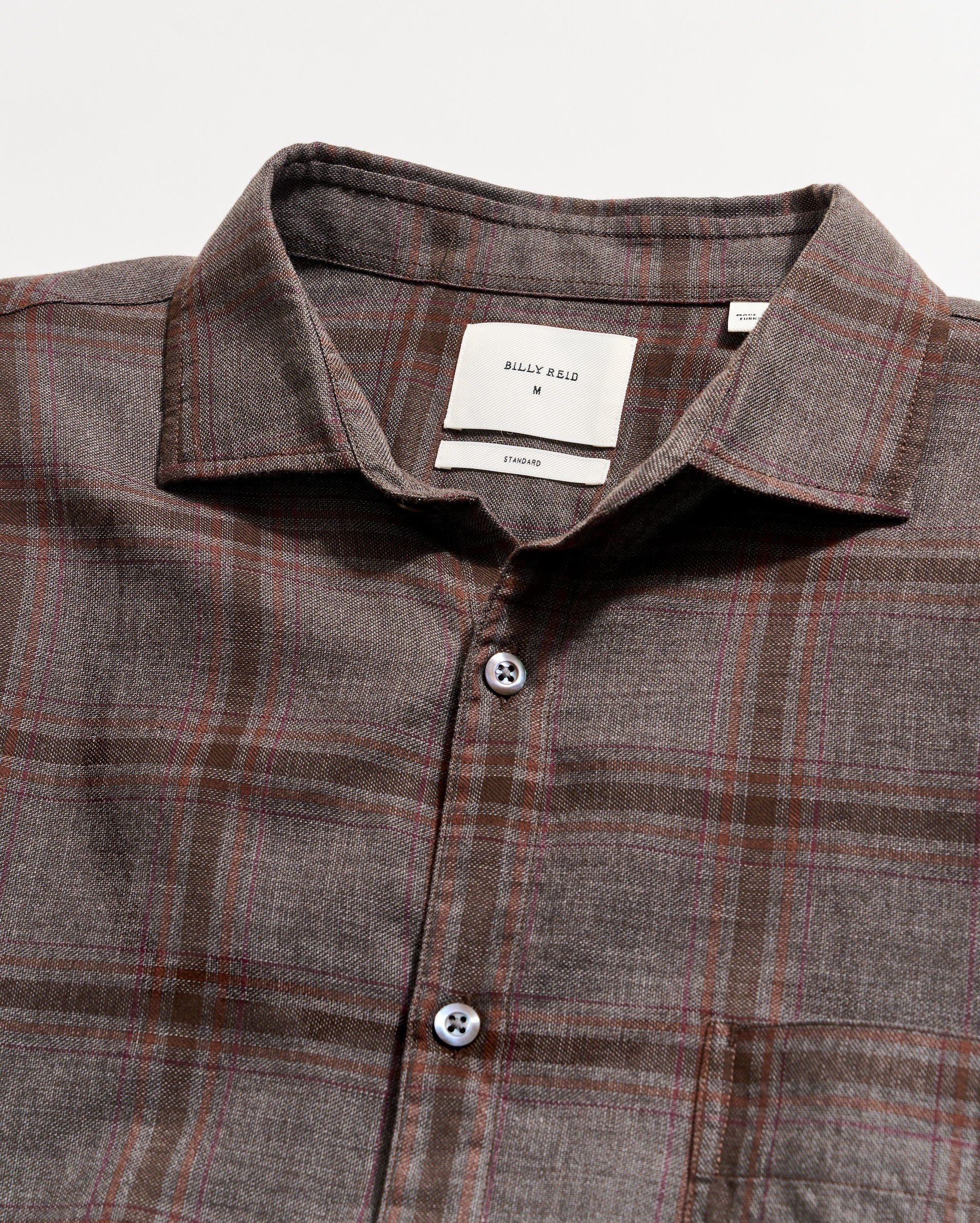 Plaid shirt with a collar and buttons on a light gray background