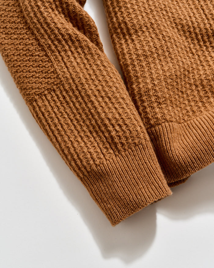 Close-up of a brown knitted sweater on a light background