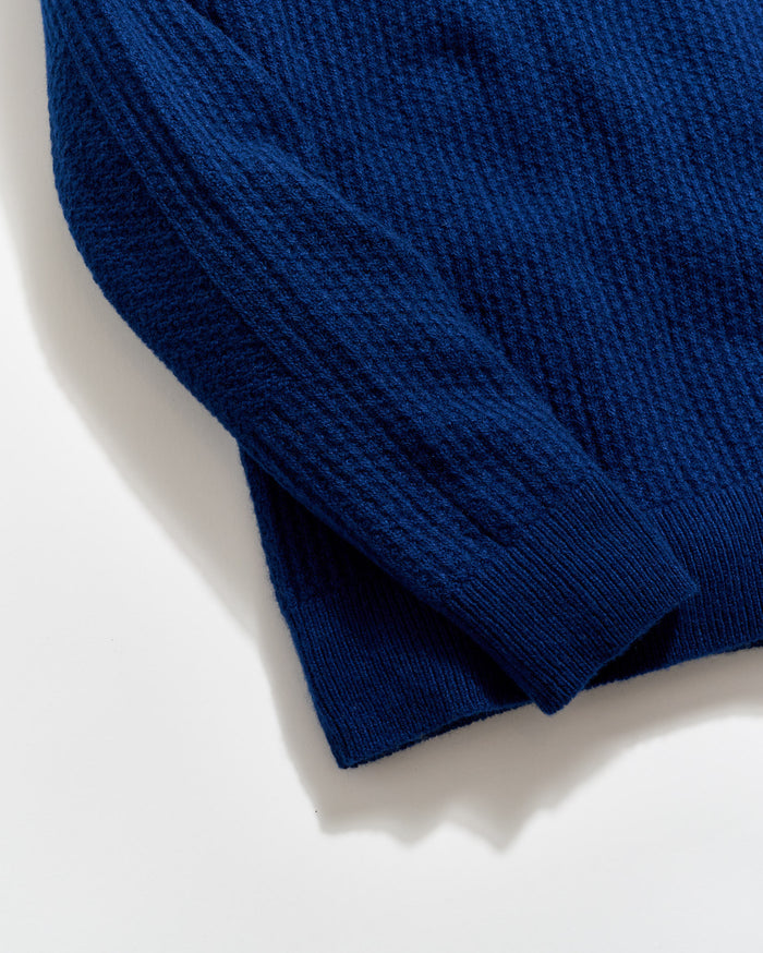 Close-up of a blue sweater on a light background