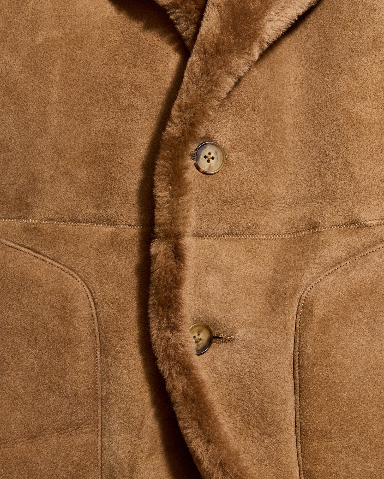 Close-up of a brown suede jacket with buttons