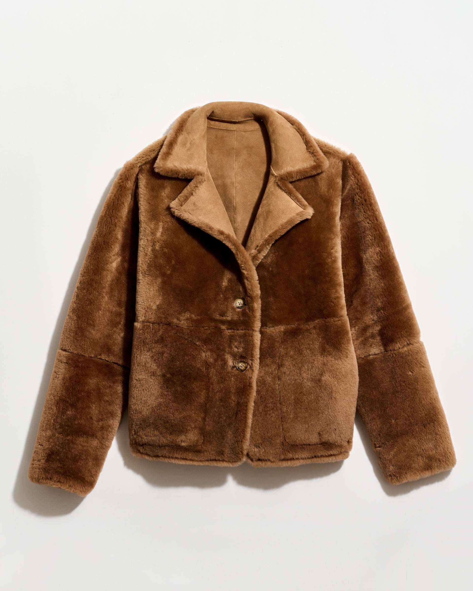 Brown faux fur jacket on a light beige background