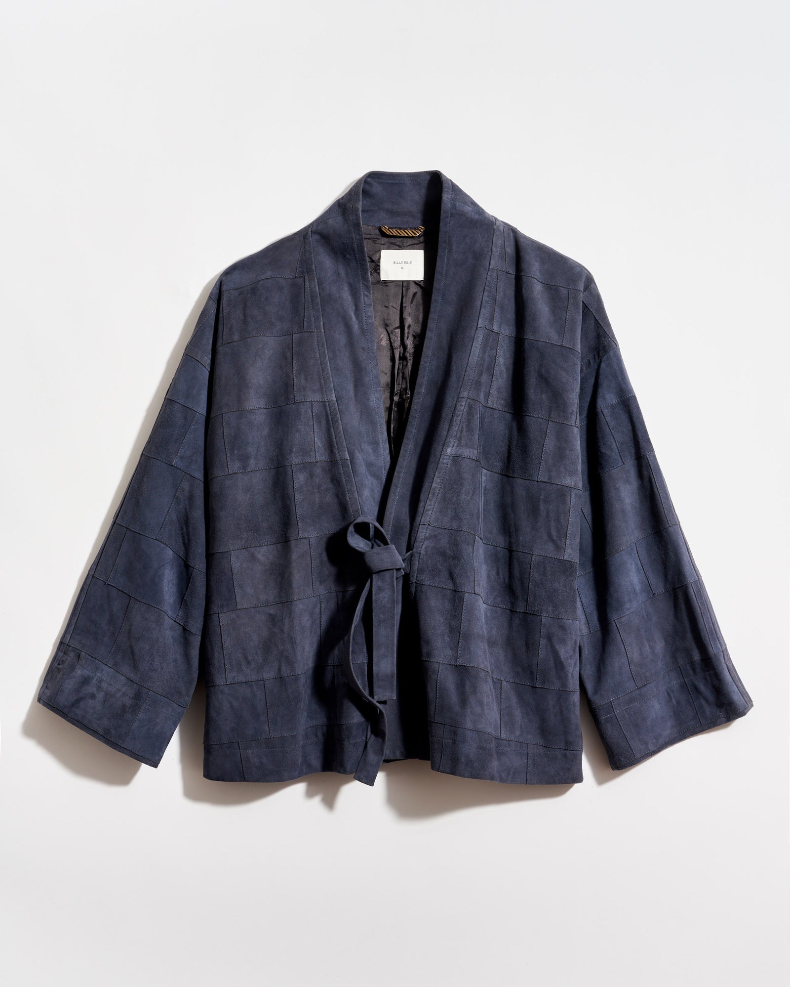 Navy blue checkered wrap coat on a light gray background