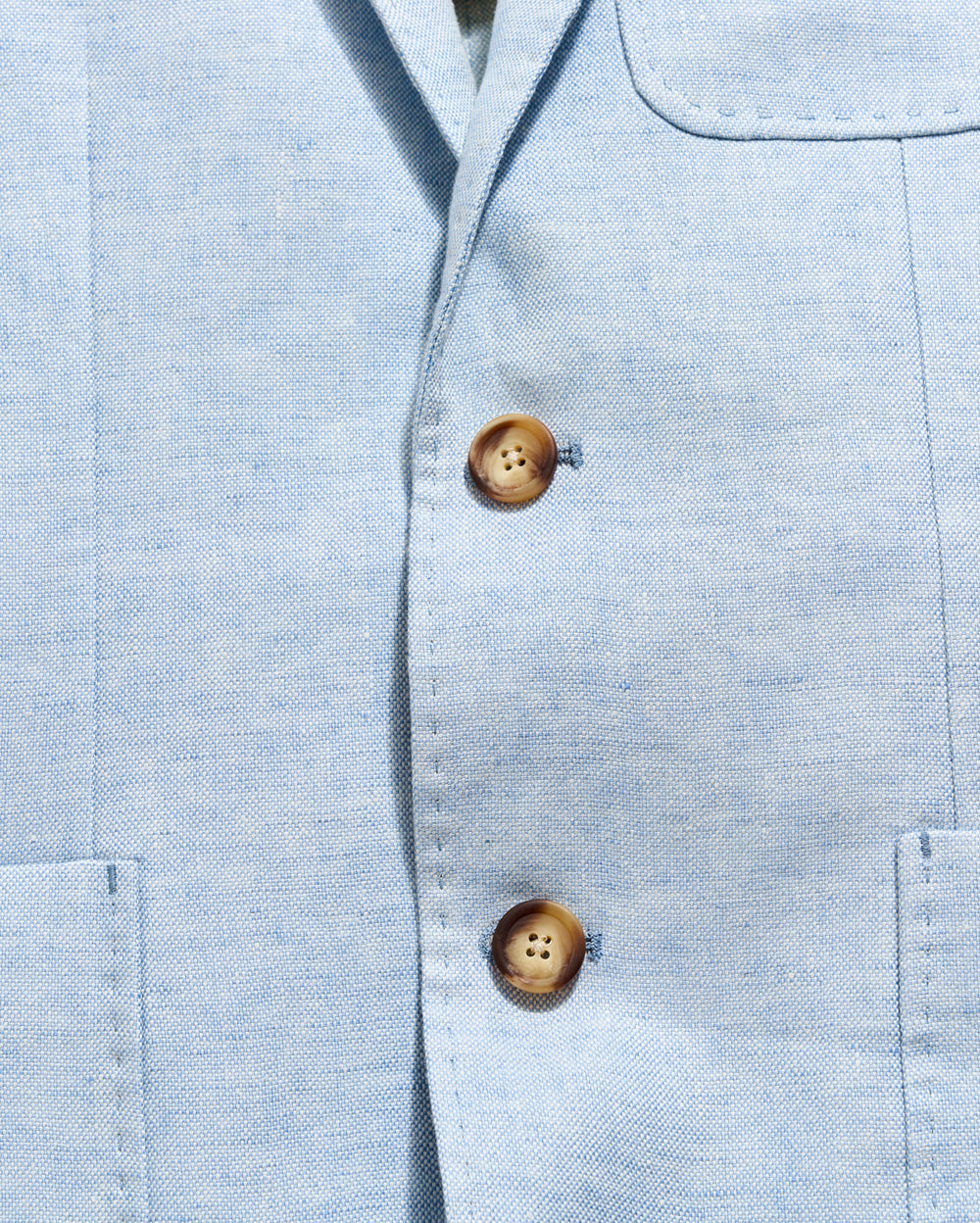 Close-up of a light blue shirt with wooden buttons