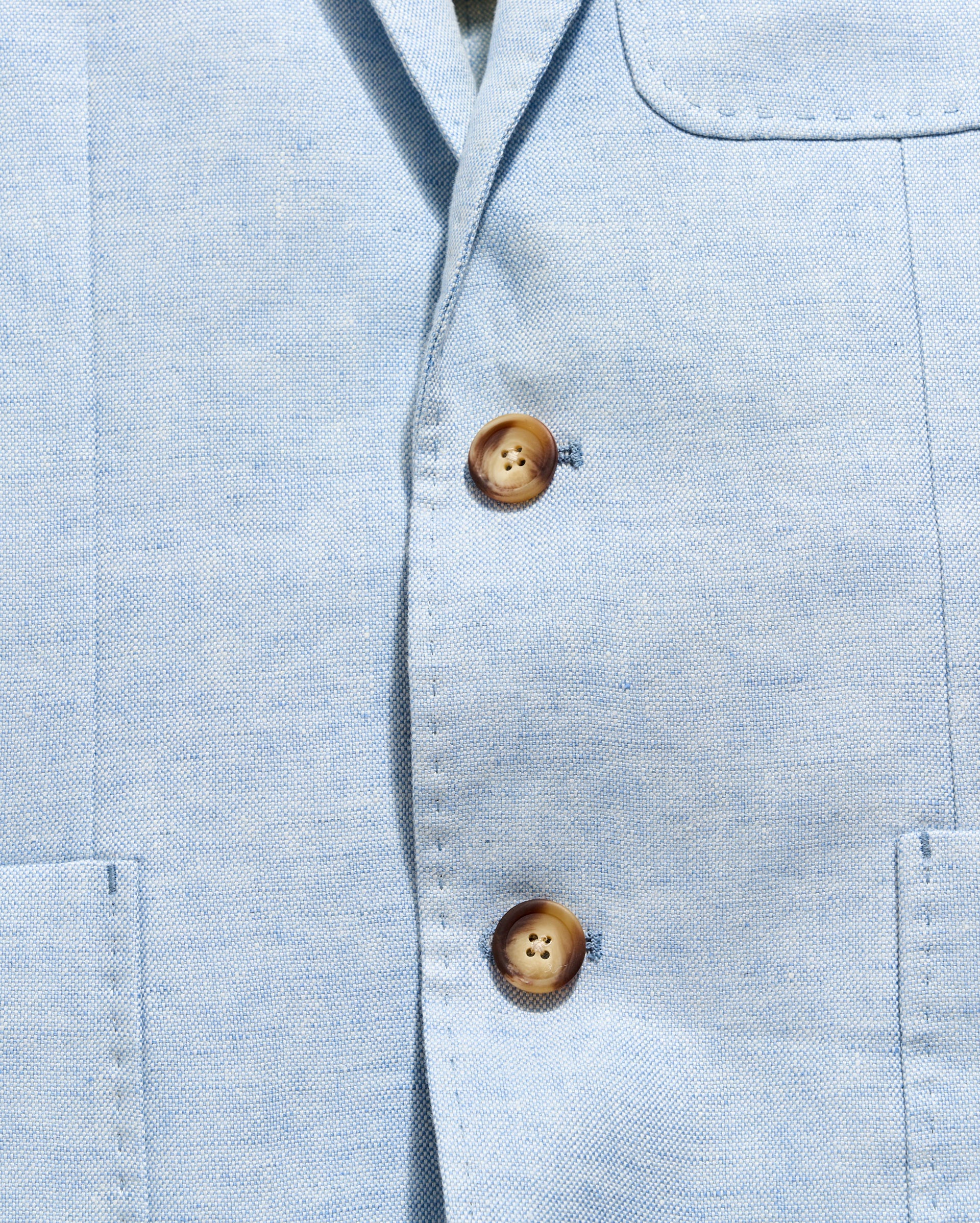 Close-up of a light blue shirt with wooden buttons