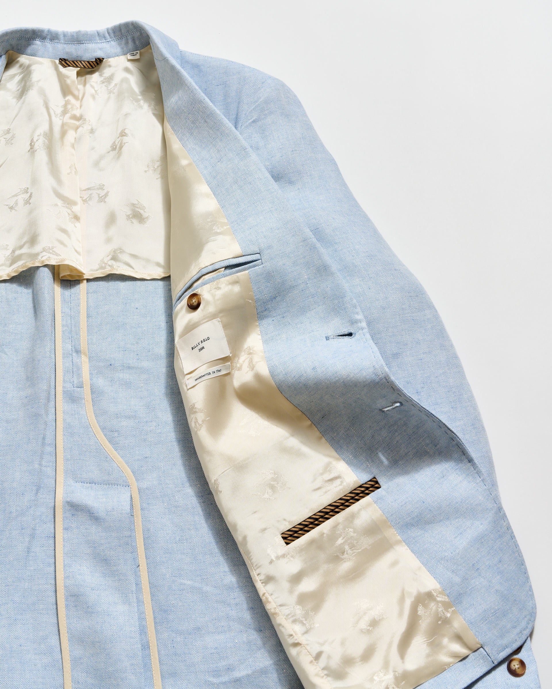 Light blue jacket with beige lining on a white background