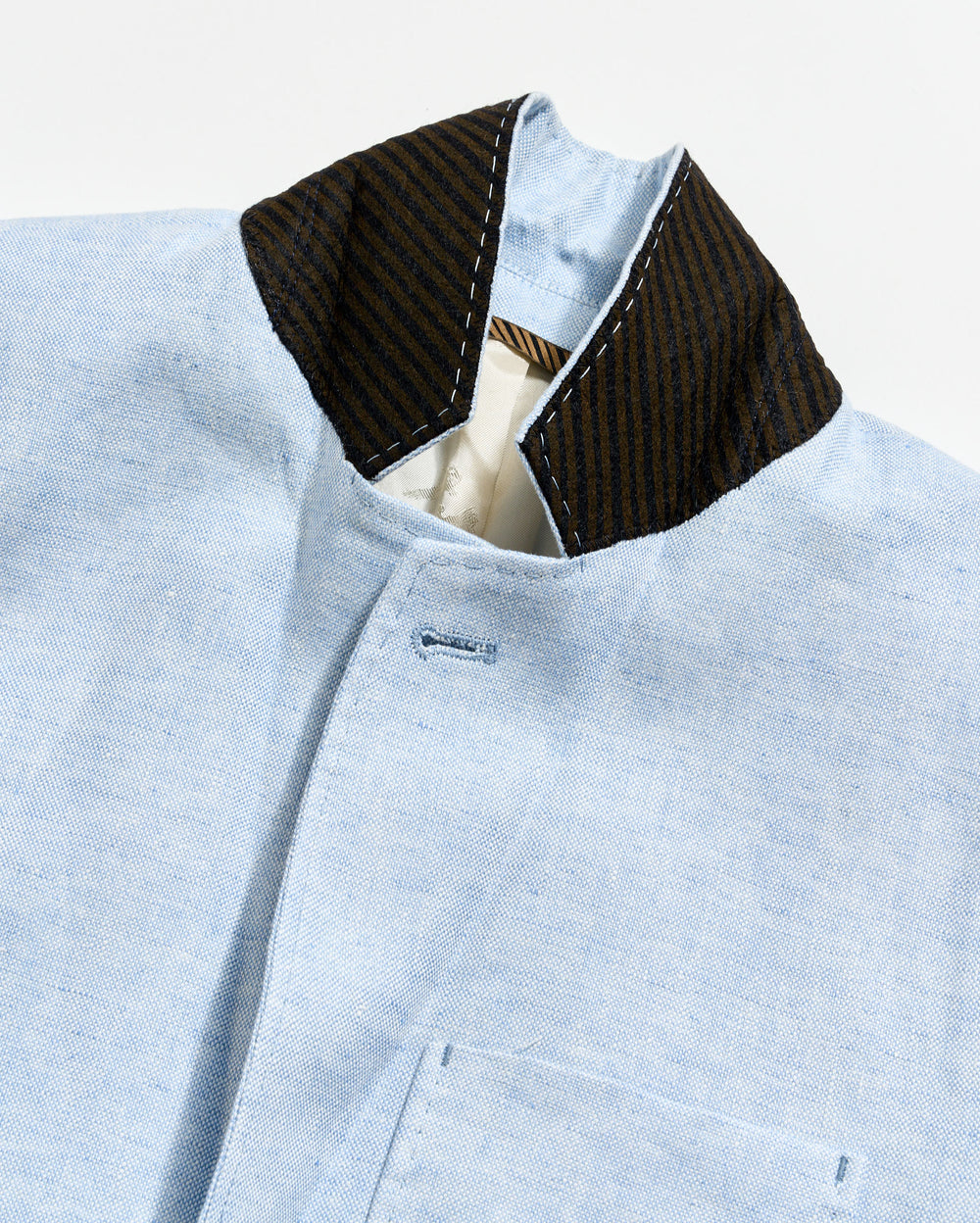 Light blue shirt with a dark collar on a light gray background