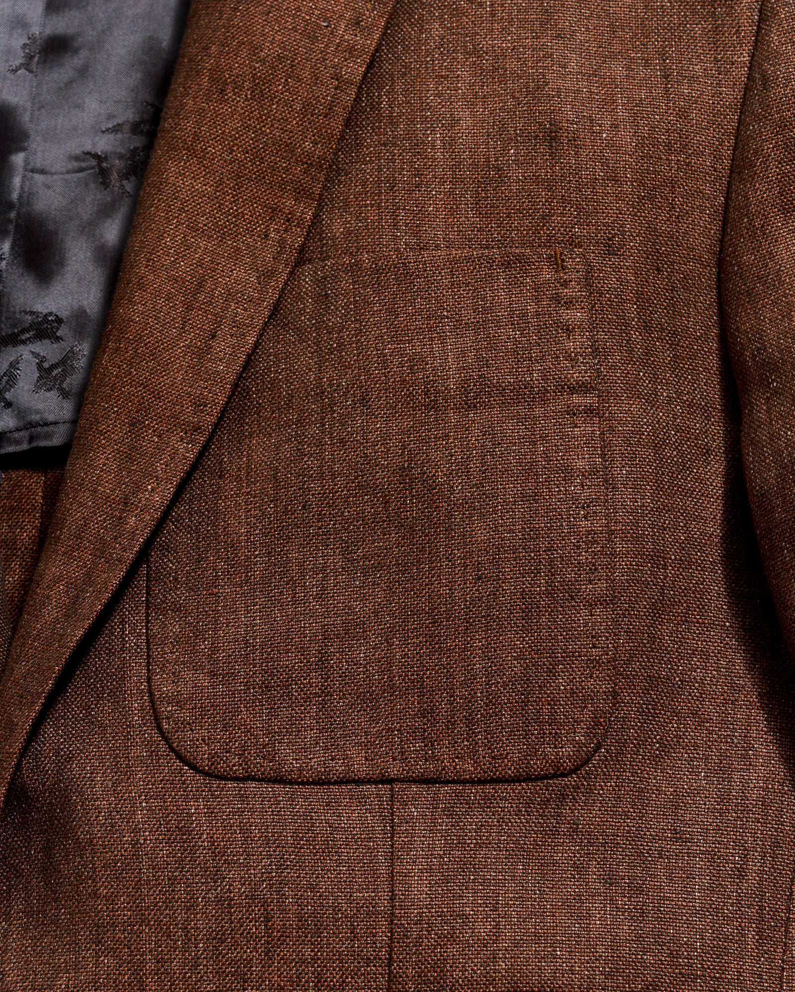 Close-up of a brown textured blazer with a pocket