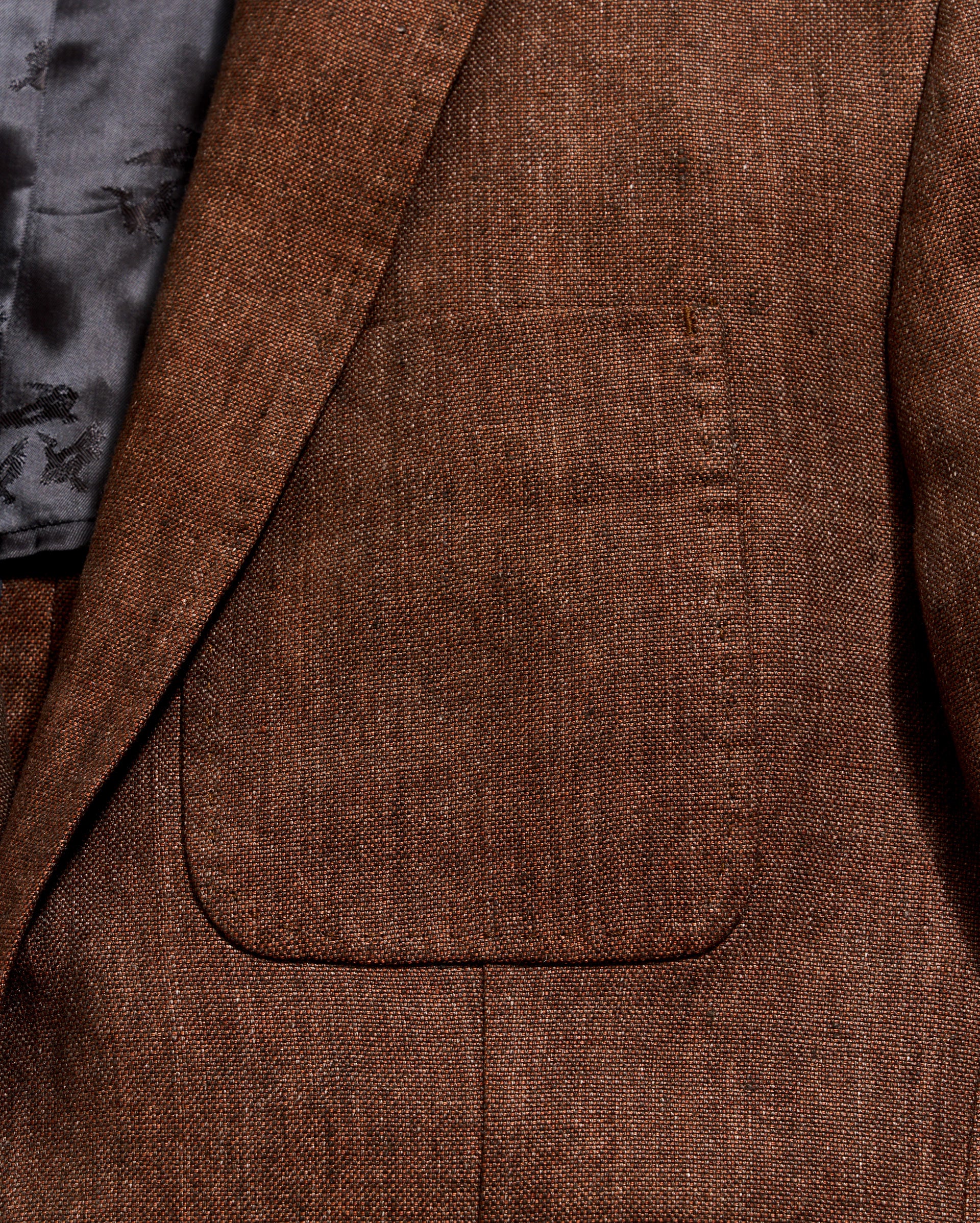 Close-up of a brown textured blazer with a pocket
