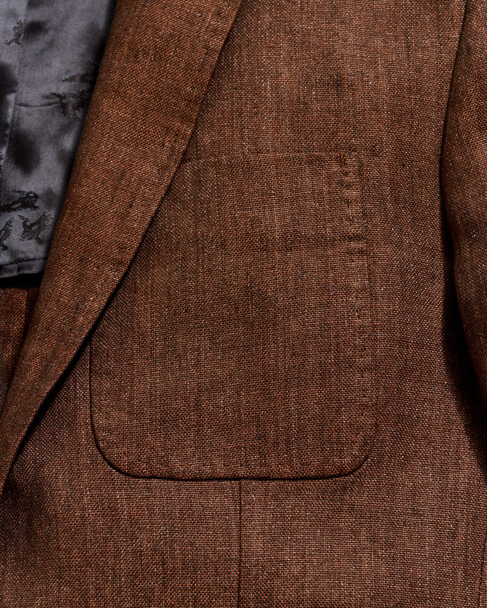 Close-up of a brown textured blazer with a pocket