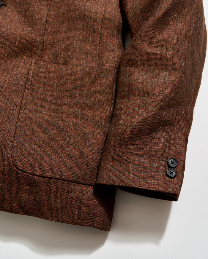 Brown textured fabric with a pocket and button on a white background