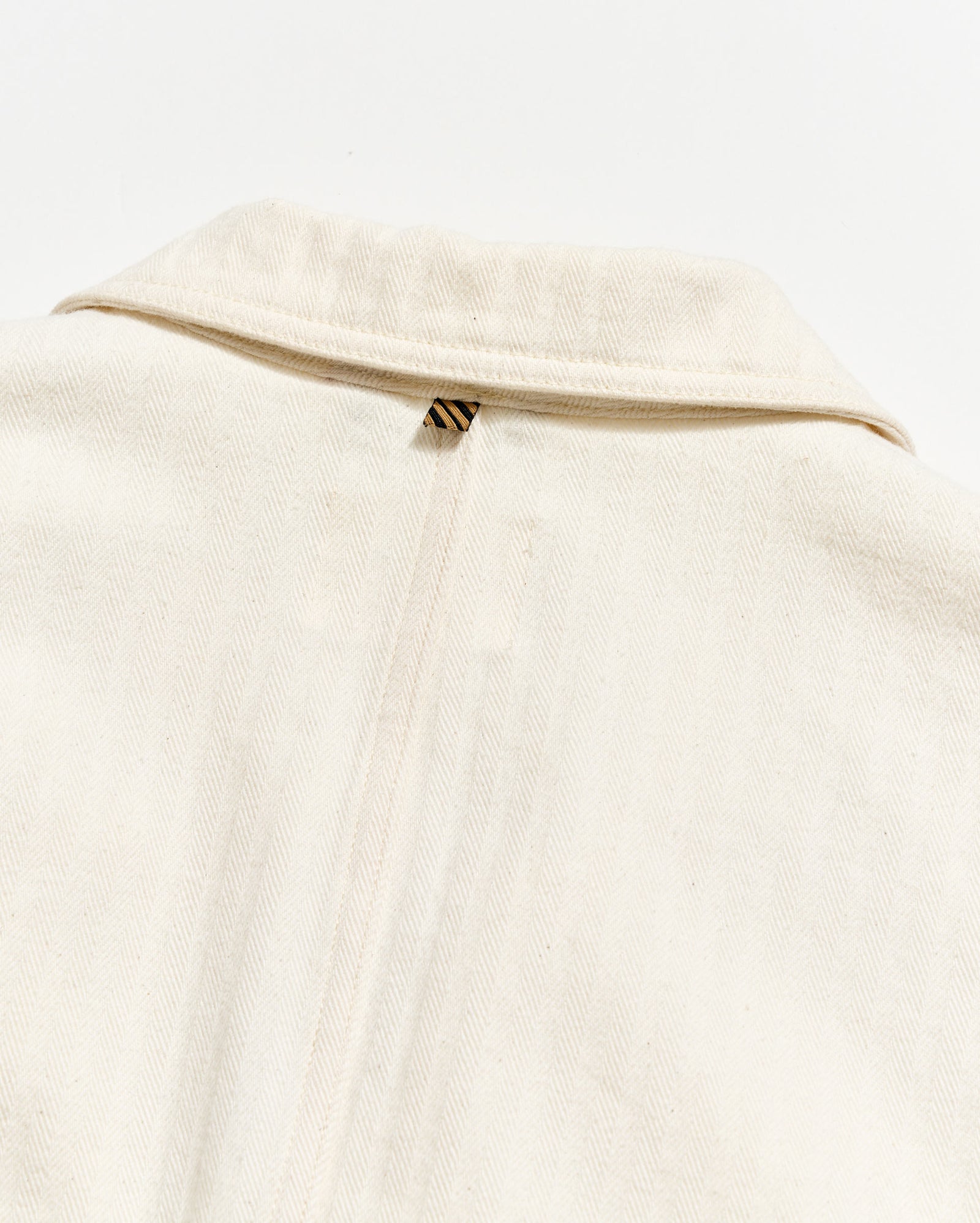 Close-up of a beige garment with a zipper on a white background