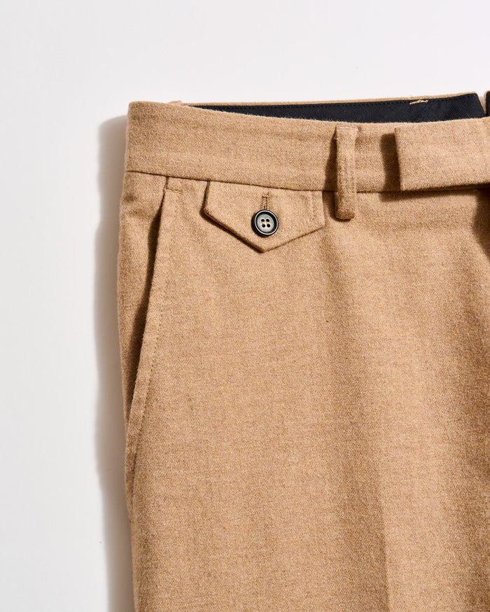 Close-up of beige pants with a button on a light gray background