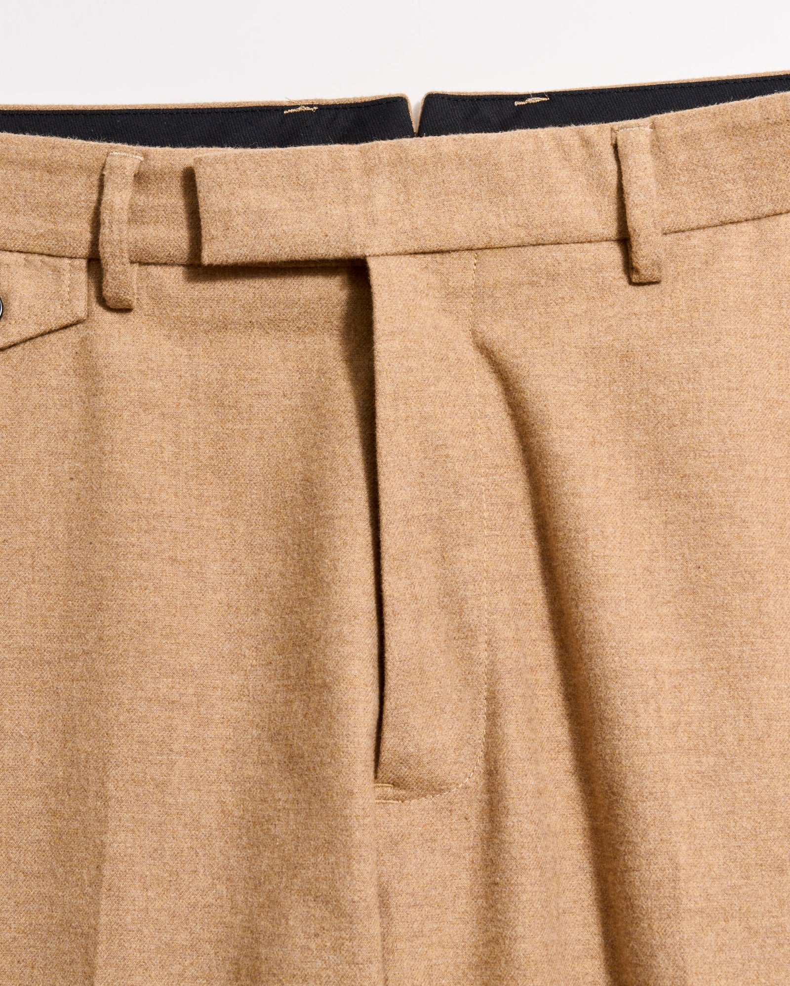 Close-up of beige pants with a white background