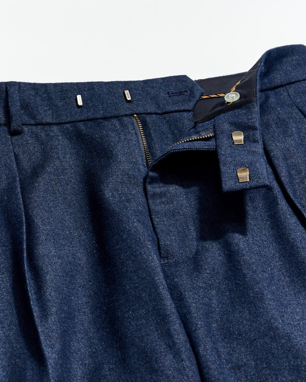 Close-up of a blue suit jacket with buttons and a tag on a light gray background