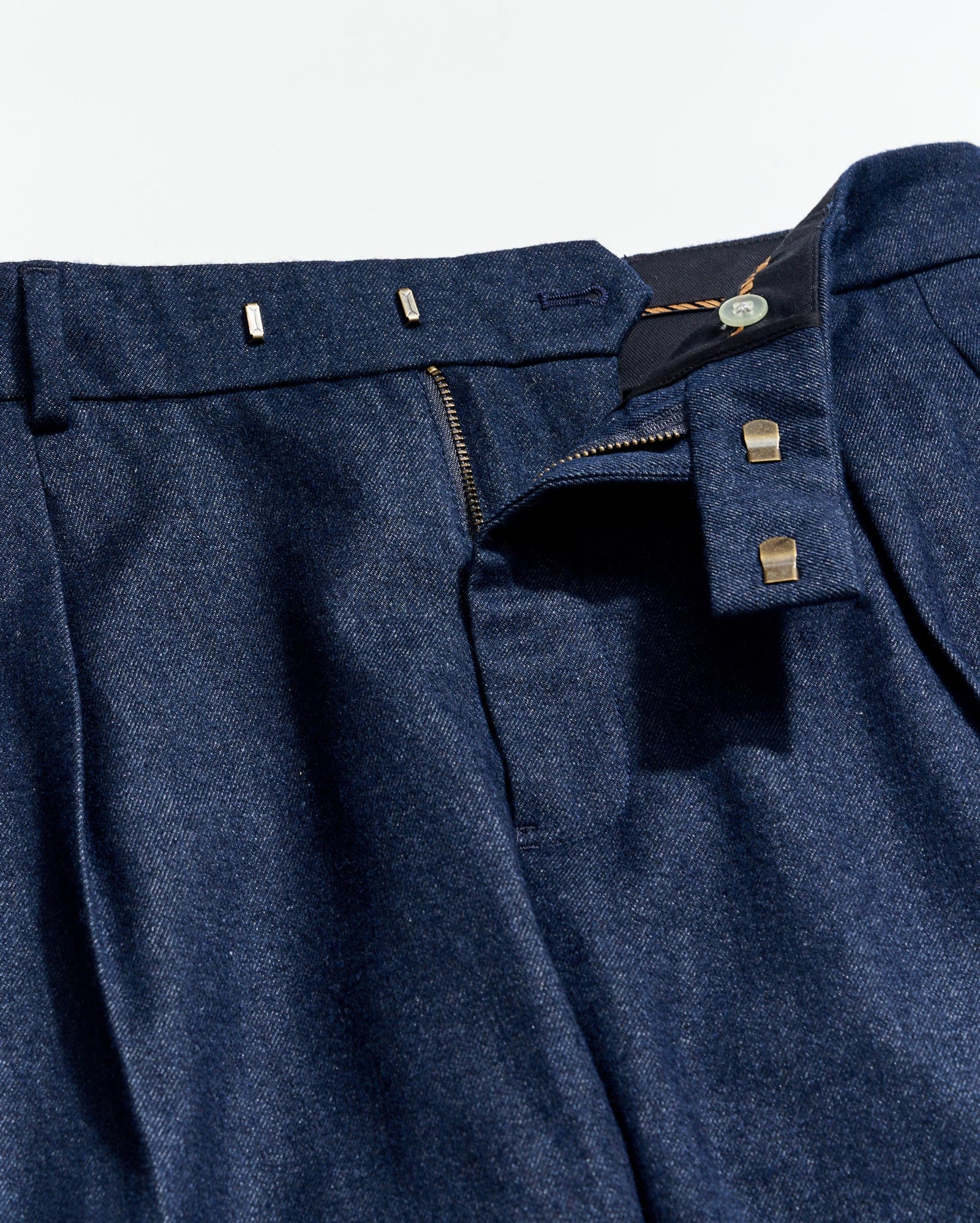 Close-up of a blue suit jacket with buttons and a tag on a light gray background