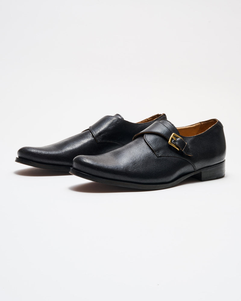 Single Monk Shoe in Black showing the side view of the heel and buckle. 