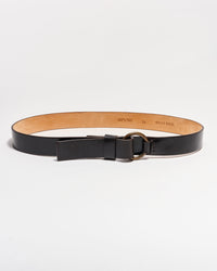 A black leather belt with a tan interior, featuring a round metal buckle and a single loop, displayed on a white background.