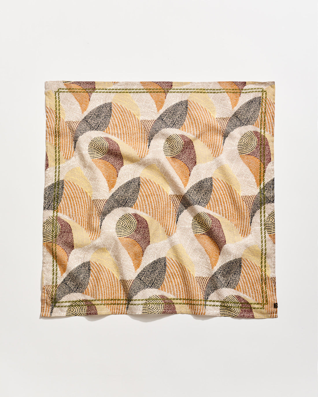 A square cloth napkin with an abstract, geometric pattern in earthy tones of beige, brown, rust, and olive green, featuring curved lines and shapes on a white background. The napkin is slightly wrinkled.