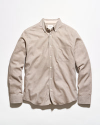 A light beige long-sleeve button-down shirt with a single chest pocket, laid flat against a white background.