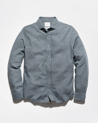 A men's long-sleeve button-down shirt in a fine blue and white micro-check pattern, displayed flat against a light gray background.