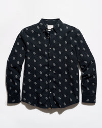 A long-sleeve button-up shirt in black with a repeating small white paisley pattern, laid flat against a white background.