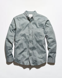 A long-sleeve button-up shirt with a gray and white chevron pattern, laid flat against a white background.