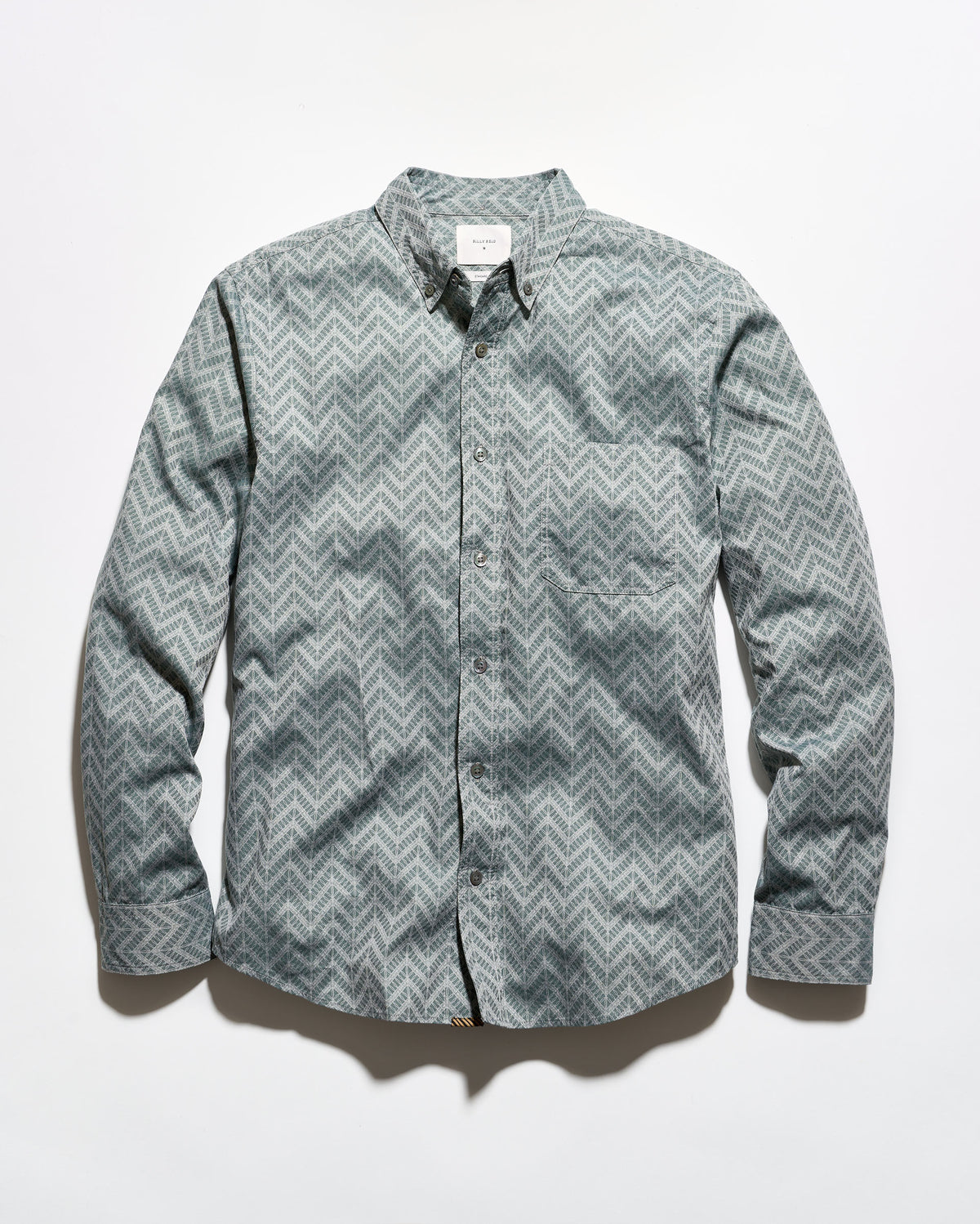 A long-sleeve button-up shirt with a gray and white chevron pattern, laid flat against a white background.
