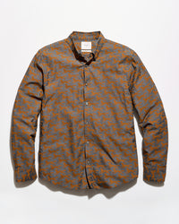 A long-sleeve button-up shirt with an abstract geometric pattern in orange and gray, laid flat against a white background.
