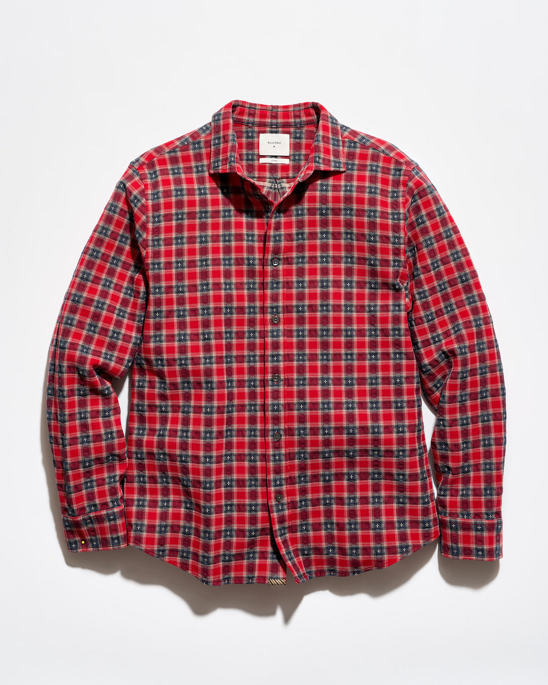 A red and black plaid long-sleeve button-up shirt laid flat against a white background.
