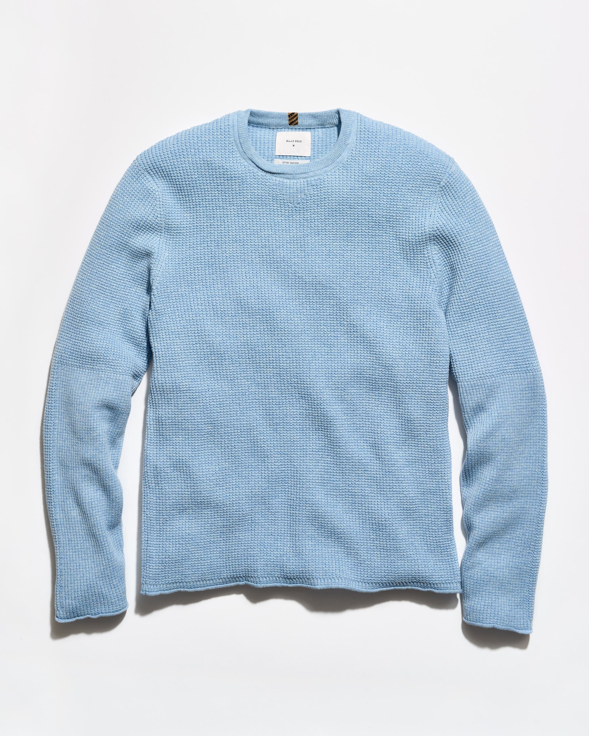 A light blue textured knit crewneck sweater with long sleeves, laid flat against a clean white background.