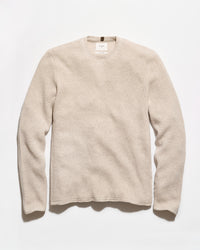 A light beige crewneck sweater with a textured waffle knit pattern, laid flat against a clean white background.