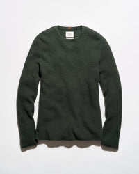 A dark forest green waffle-knit long-sleeve crewneck sweater laid flat against a light gray background.