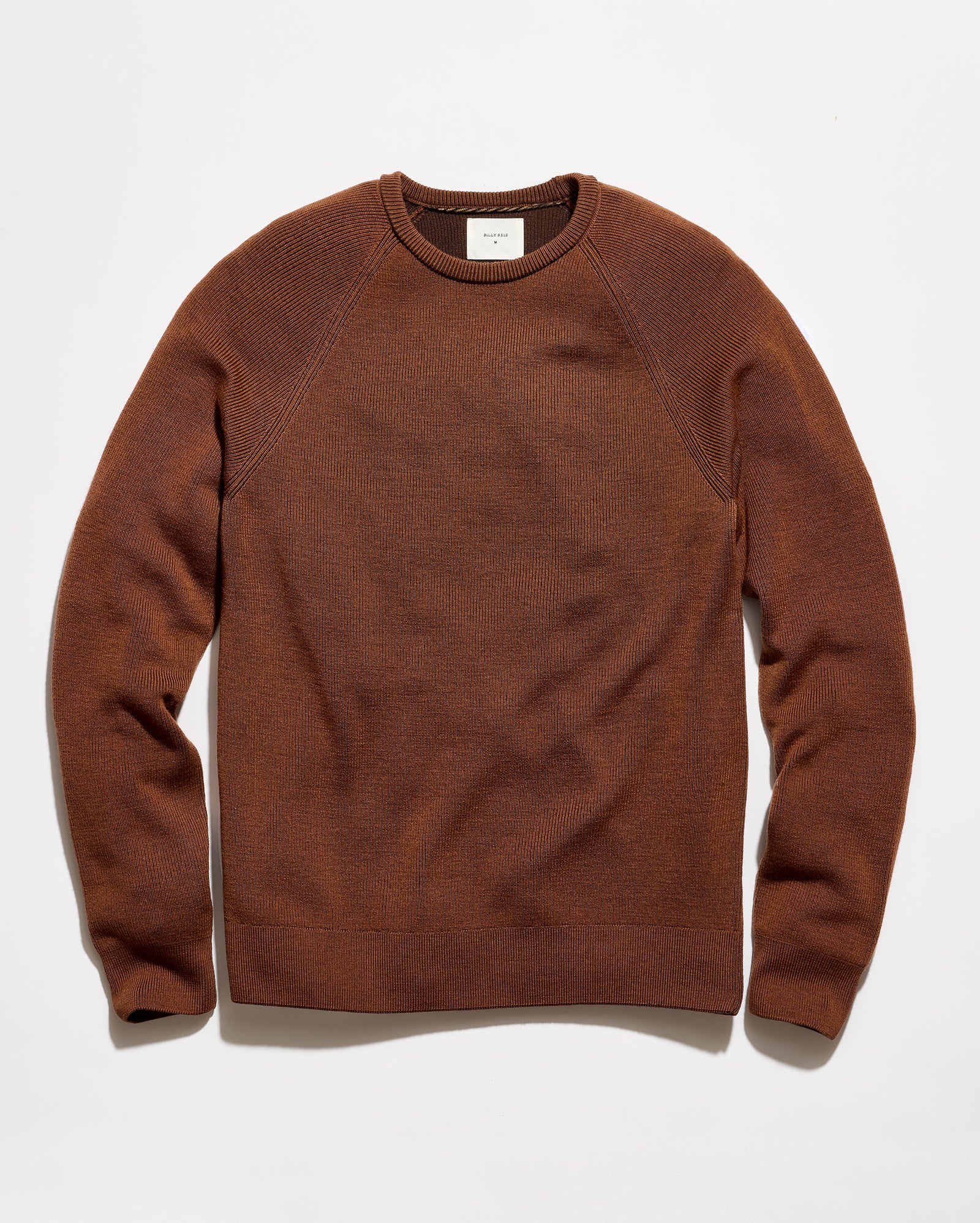 A brown crewneck knit sweater with raglan sleeves, laid flat against a clean white background.
