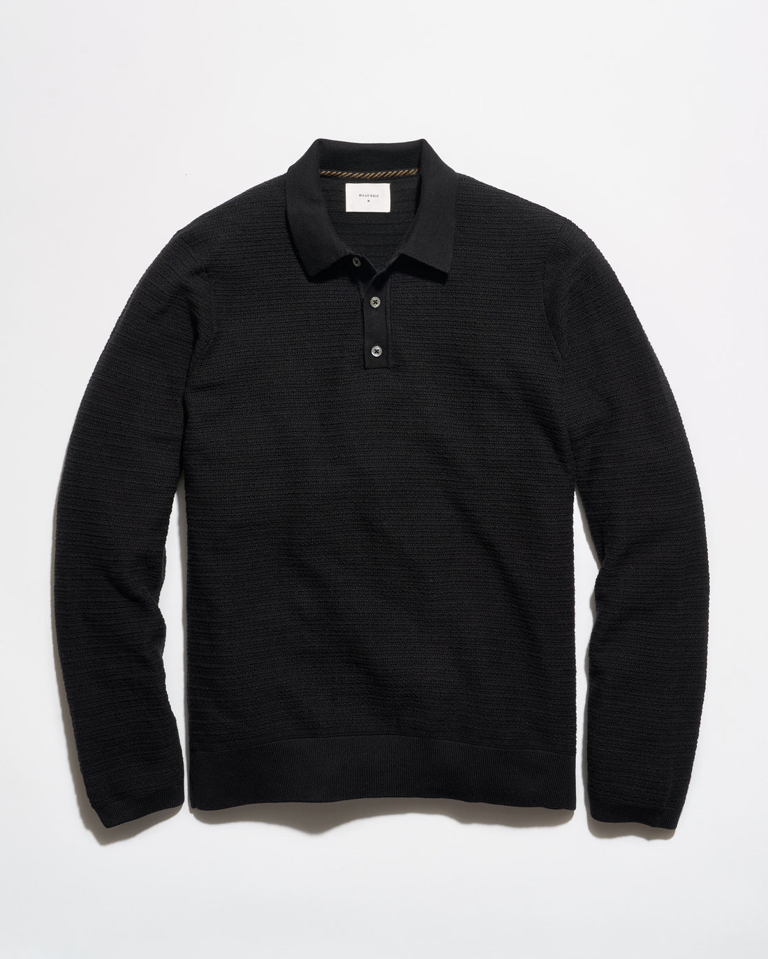 A black long-sleeve knit polo shirt with a textured horizontal rib pattern, laid flat against a clean white background.