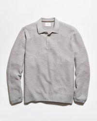 A light gray ribbed knit polo sweater with a collar and three-button placket, laid flat against a white background.