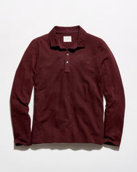 A long-sleeve polo shirt in a deep burgundy color, laid flat against a clean white background.