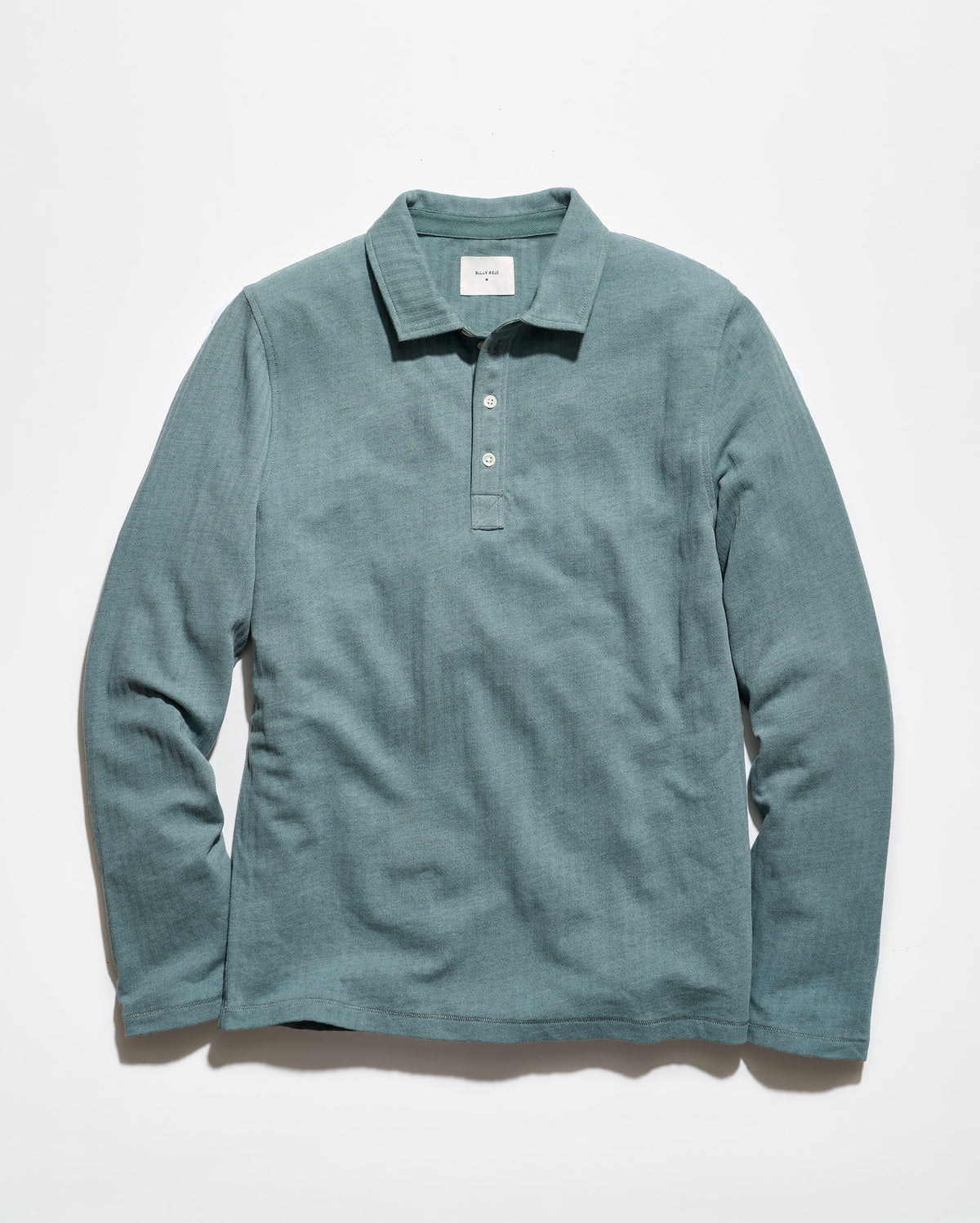 A long-sleeve polo shirt in a muted teal-green color, laid flat against a clean white background.