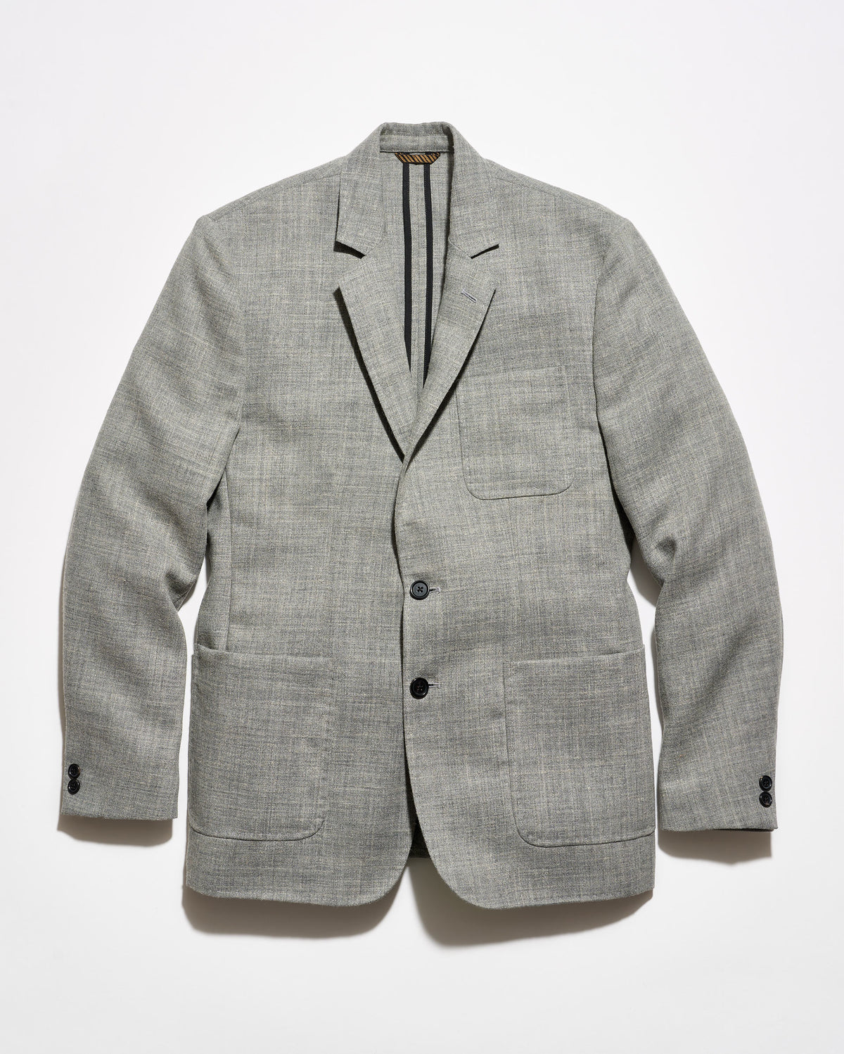 A light gray textured blazer with black tape reinforcement at the back interior, featuring a two-button closure and two front patch pockets, displayed flat against a white background.