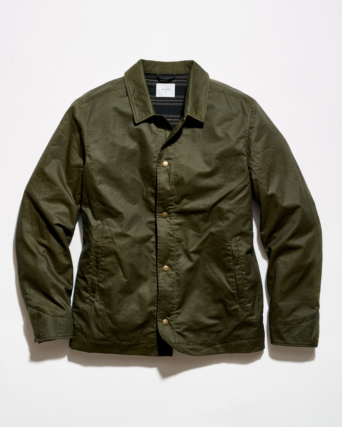 An olive green waxed cotton jacket with a button-up front, laid flat against a white background.