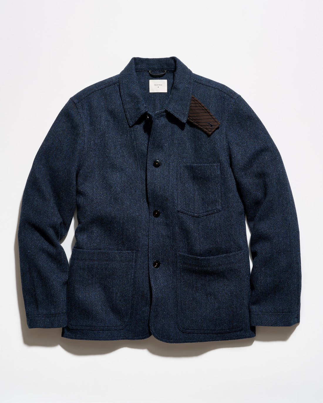A dark navy blue textured jacket with a pointed collar, black snap-button front, a chest pocket, and two large lower patch pockets, photographed flat against a white background.
