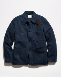 A dark navy blue textured jacket with a pointed collar, black snap-button front, a chest pocket, and two large lower patch pockets, photographed flat against a white background.