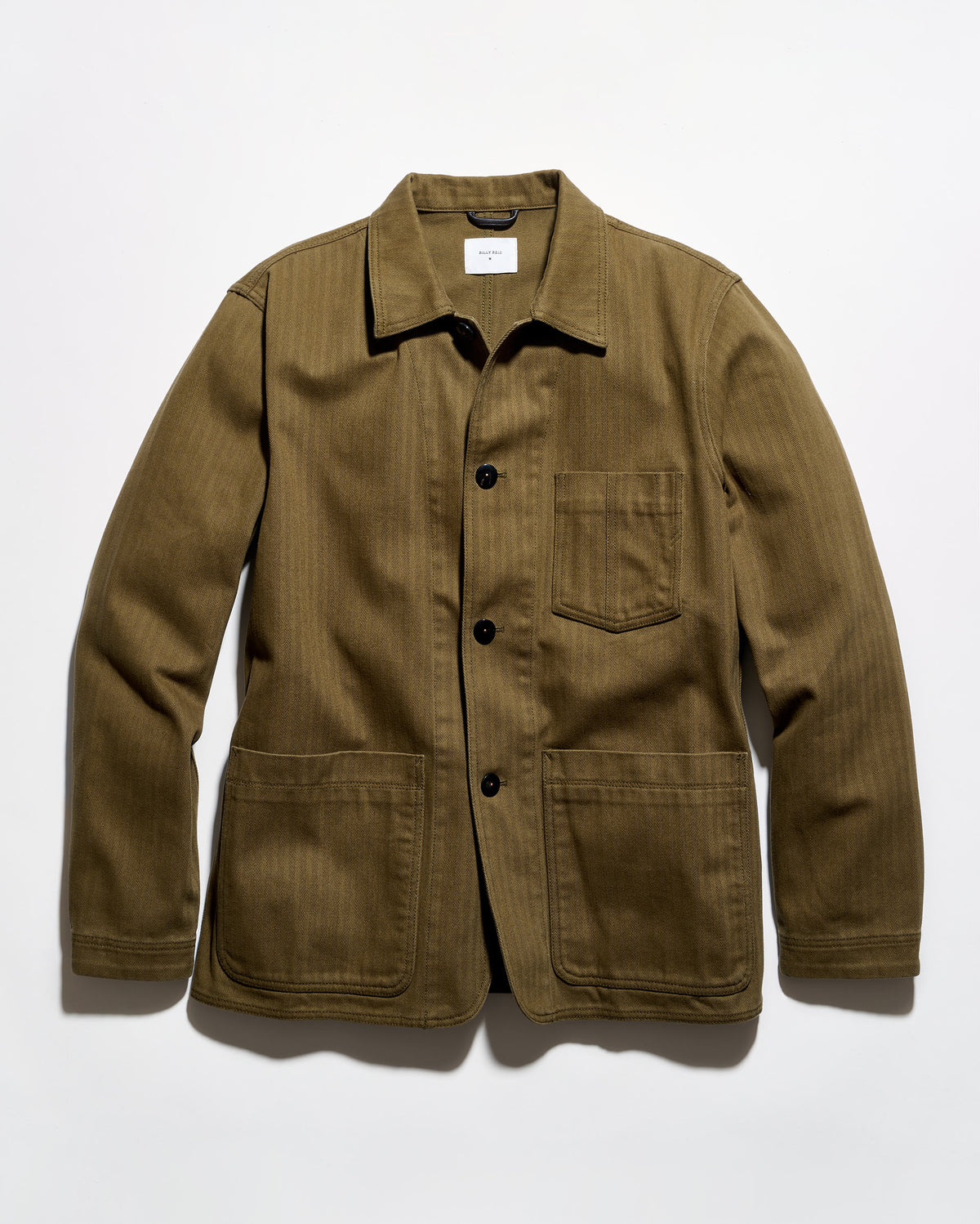 An olive green corduroy utility jacket with a pointed collar, black snap-button front, and four front pockets, laid flat against a white background.