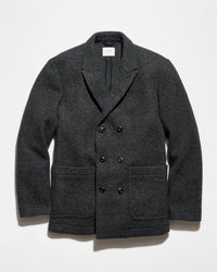 A dark charcoal gray double-breasted wool-blend jacket with notch lapels, dark buttons, and front patch pockets, displayed flat against a light gray background.