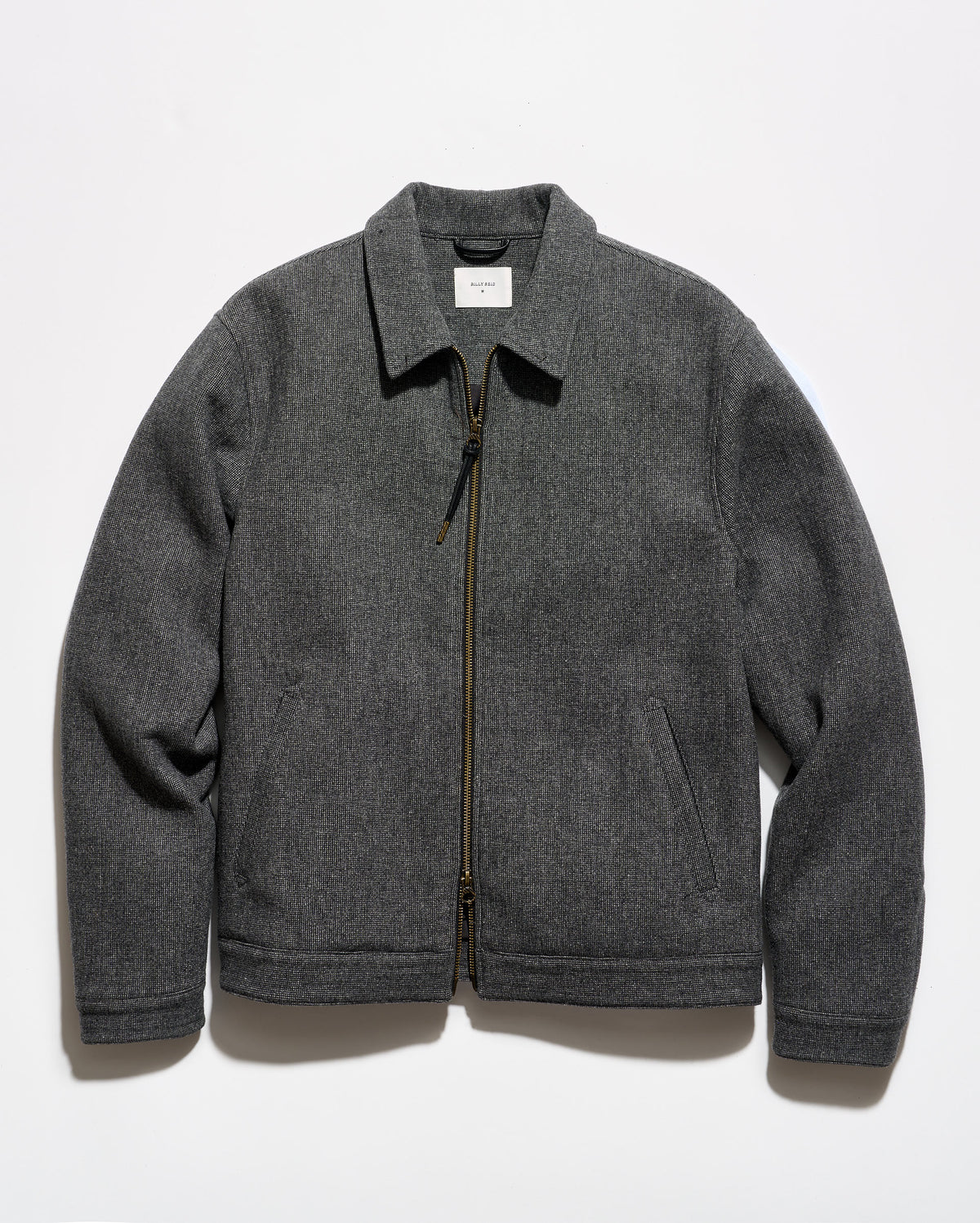 A dark gray zip-up jacket with a pointed collar and side pockets, laid flat against a white background.
