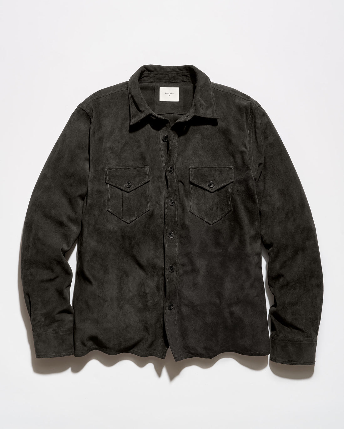 A dark charcoal gray suede long-sleeve button-up shirt with two chest flap pockets, laid flat against a light gray background.